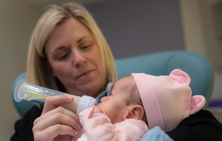 Nurse feeding a baby in the NICU