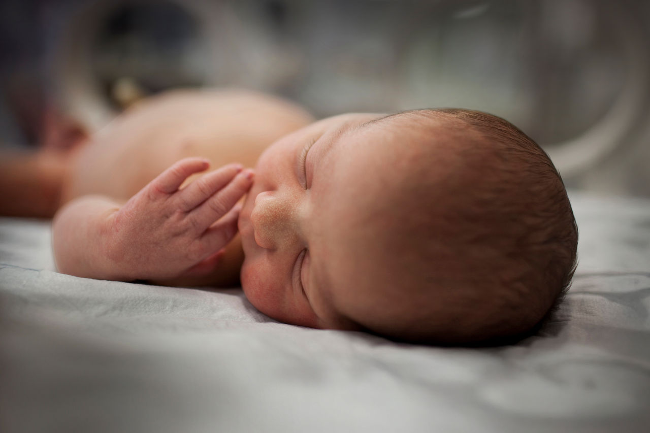 Baby in NICU crib.