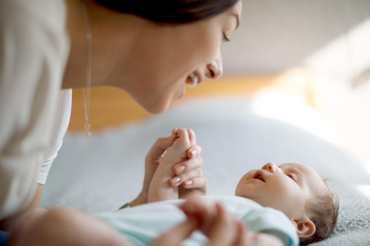 Close up of mom leaning over and smiling at baby